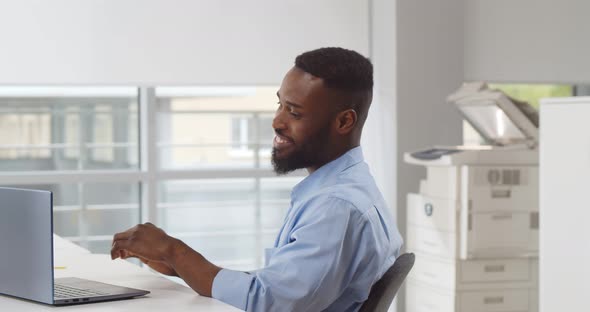 Happy Relaxed African Young Male Rest in Chair Distracted From Computer Work