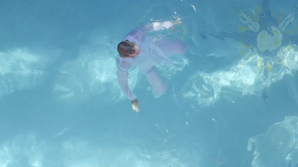 Man Swimming In White Clothes In Swimming Pool