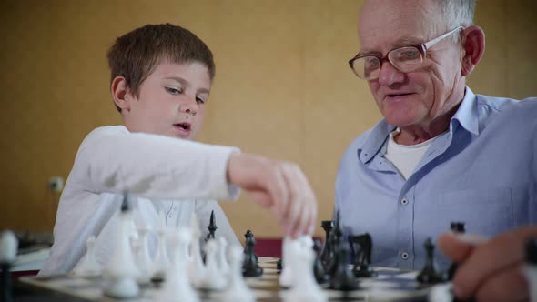 Board Games, an Elderly Man in Glasses for Vision and a Happy Cute Male Child Have Fun Together