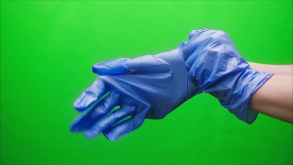 Closeup of Doctor Hands Wearing Blue Medical Gloves for Safety Protection Green Background Vaccine