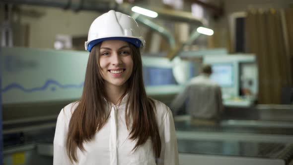 Portrait of Beautiful Young Woman in Helmet Presenting Production of Furniture By International