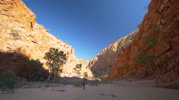 Person walks across sand through gorge, Central Australia
