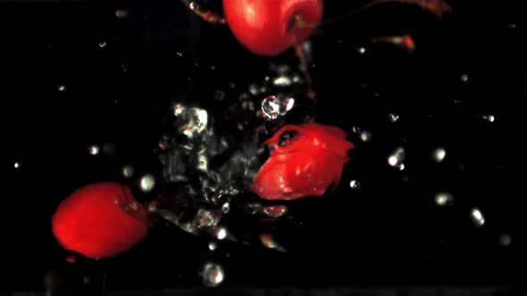 Super Slow Motion Ripe Cherry Falls Into the Water with Splashes