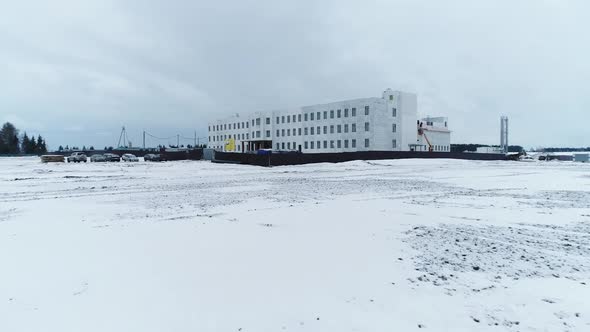 Construction Site of Industrial Building in Snowy Field