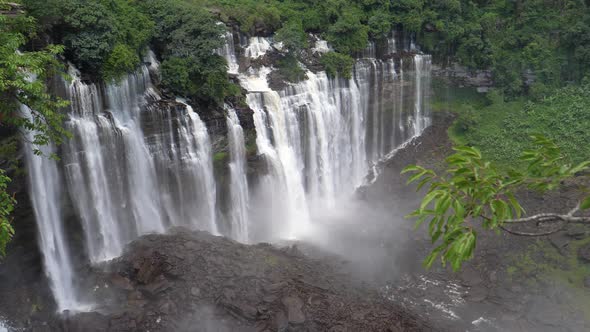 Kalandula Falls spraying water over bushes and tart-like rocks in Angola