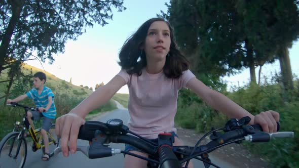 POV of a young girl enjoying a bicycle ride on the rural countryside