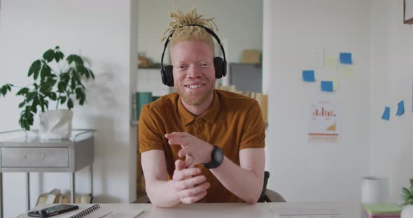 Albino african american man with dreadlocks making video call on the laptop