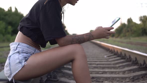 Railroad Young Woman on Rails with a Smartphone