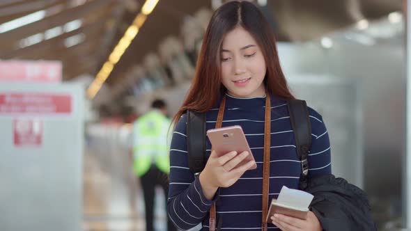 Pretty young woman traveler checking boarding time at airport