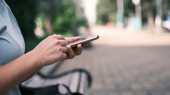 Close Up of Young Woman Hands Using and Holding Smart Phone Scrolling Up and Down on Touchscreen