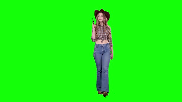Sheriff Girl Holds a Revolver in Her Hands and Aiming at the Villain. Green Screen