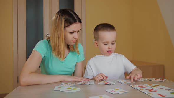 Cute Child Studying with His Young Mother Playing Educational Card Game