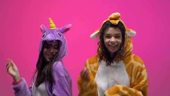 Women in Unicorn and Giraffe Pajamas Dancing on Carnival Party, Having Fun