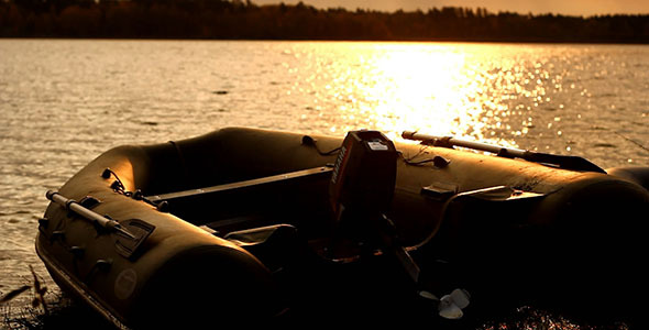 Rubber Motorboat On Lake Coast At Sunset