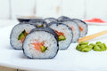 Traditional eastern dish with salmon sushi rolls on a white plate. Close-up. - PhotoDune Item for Sale
