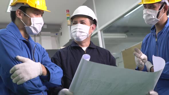 Asian male engineer discuss about factory project with foreman and colleague at industrial plant