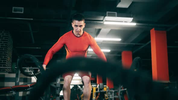 Young Man Does Crossfit Training with Battle Ropes.