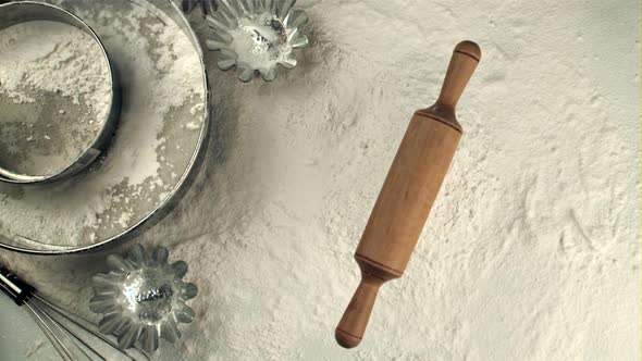 Super Slow Motion Wooden Rolling Pin Falls Into a Pile of Flour on the Table