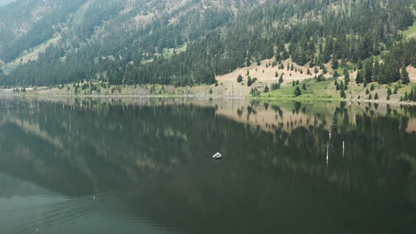 Aerial, small motor boat sailing on Earth Quake Lake in Montanna