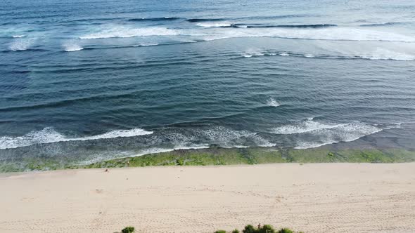 Drone flying along the beach with waves