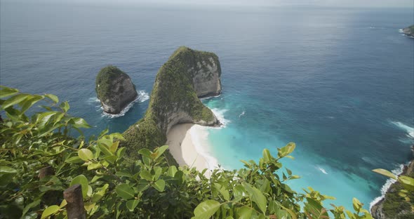 Push in Reveal Shot of Stunning Tropical Beach with Blue Sea and Rocky Peninsula Kelingking Beach