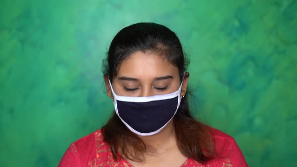 Portrait of Asian Indian girl wearing protective mask for prevention of Covid-19 coronavirus at home