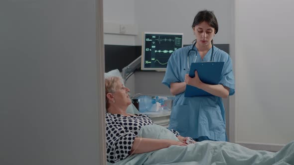 Medical Assistant Talking to Ill Patient for Checkup Visit