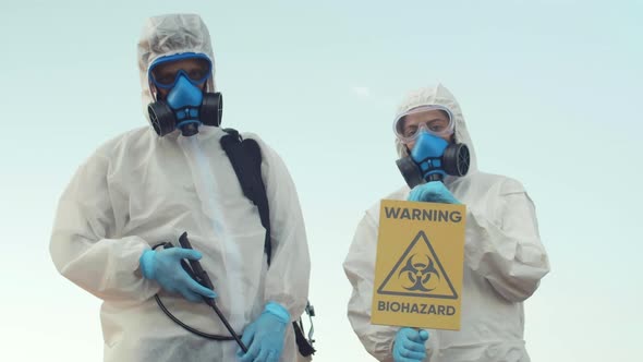 Portrait of Two Scientists Wearing Chemical Repellant Suits