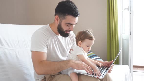 Little Daughter Pressing on Button of the Keyboard of Laptop