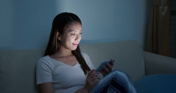 Woman watch on cellphone at home in the evening