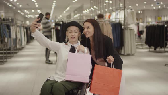 Woman in Wheelchair Taking Selfie with Friend after Shopping