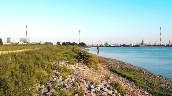 Panning drone shot made at the Antwerp harbour featuring windmills and an outfall. Made by a Dji Spa