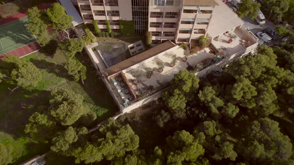 Aerial view of a residential building, surrounded by trees in Greece.