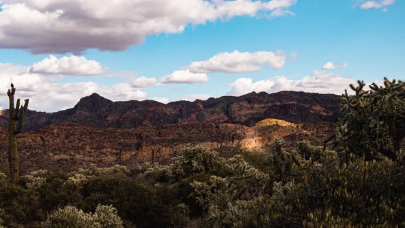 Massive storm clouds fly over canyons in the cactus-filled desert