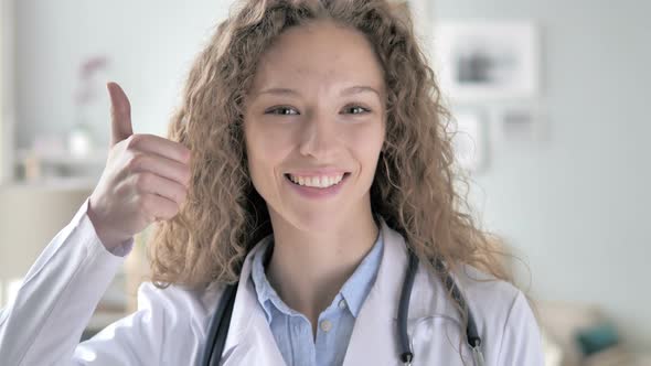 Thumbs Up by Young Lady Doctor in Clinic