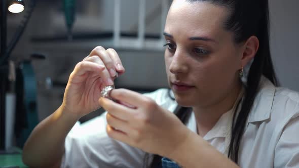 Young Focused Female Jeweller Engraving Gemstones in Ring in Slow Motion