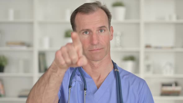 Portrait of Middle Aged Doctor Showing Call Me for Help Sign 
