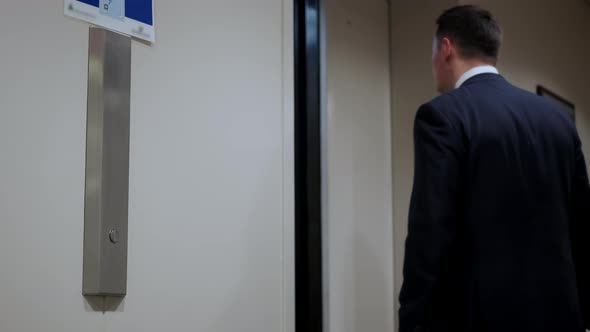 Man's Hand Presses Elevator Button to Move Up