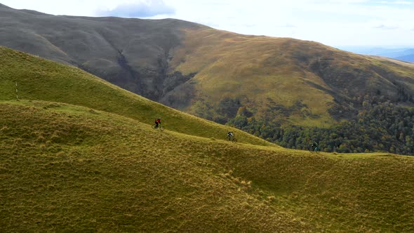 Bikers ride on off road trail on the mountain ridge. Friends riding mountain bike