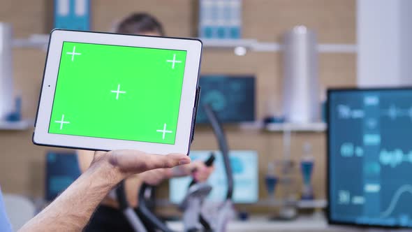 Dolly Shot of Doctor in Sport Science Holding Tablet with Green Screen