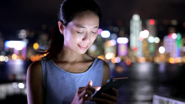 Woman using mobile phone in city 