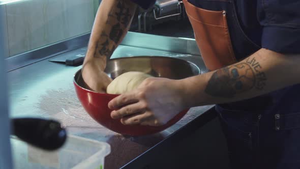 Male Chef Preparing Dough Working at the Kitchen