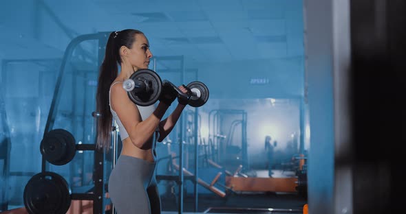 Beautiful Girl Makes Exercise for Biceps