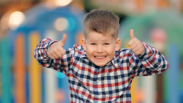 Funny Positive Little Boy Gesturing Thumbs Up on a Colourful Background