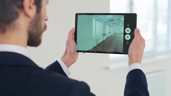 An Architect Scans the Office Space with the Help of Additional Reality Using the Digital Tablet
