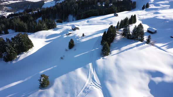 Aerial top view of snowy forest and winter in mountains and famous winter ski resort aerial view. Wi