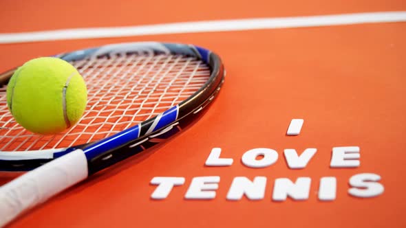 Tennis ball and racket with I love tennis text in court 4k