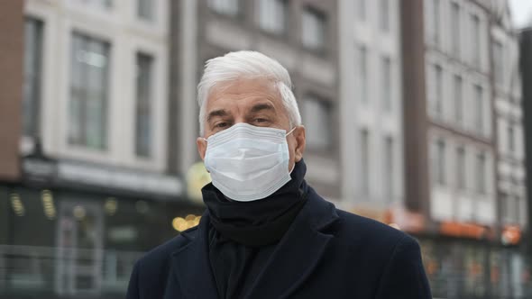 Portrait of Dutch Grey Haired Gentlemen in Black Coat and Mask Looking at Camera