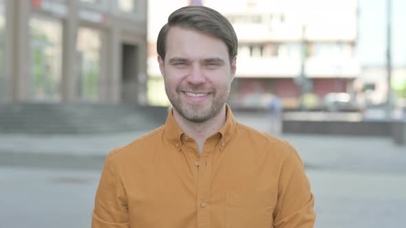 Portrait of Young Man Smiling at Camera Outdoor