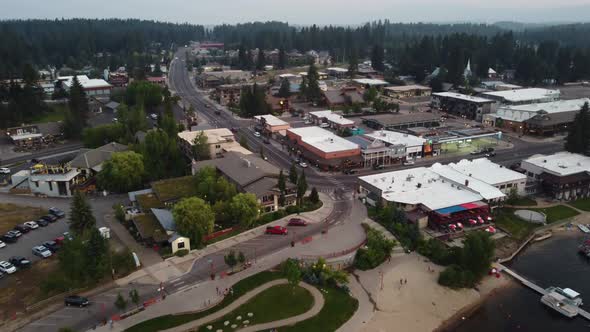 Drone shot of a car driving into the town of McCall on Payette Lake during sunset. This 4K cinematic